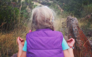 How Nature Supports Children's Mental Health and Wellbeing girl meditating in nature