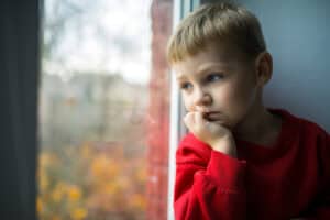 boy lookin gout of window Helping young people through grief