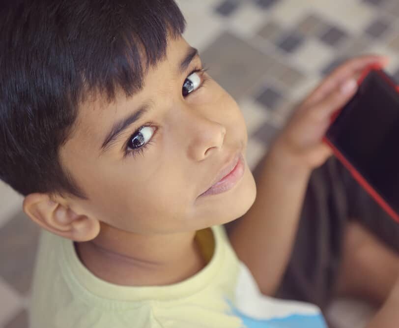 boy holding phone looking at camera - meditation mindfulness addiction