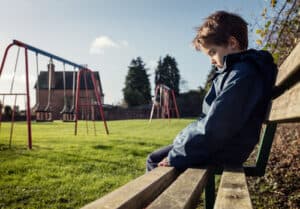 boy sitting on bench lonely - mindfulness for anti bullying connected kids